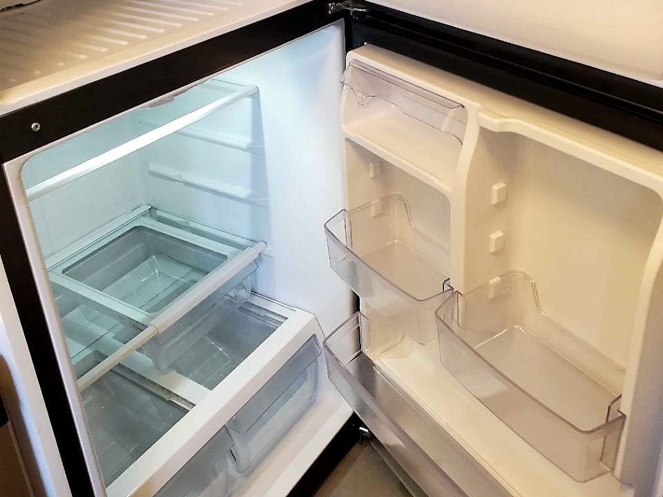 An emptied and wiped-down refrigerator, ready for move-out