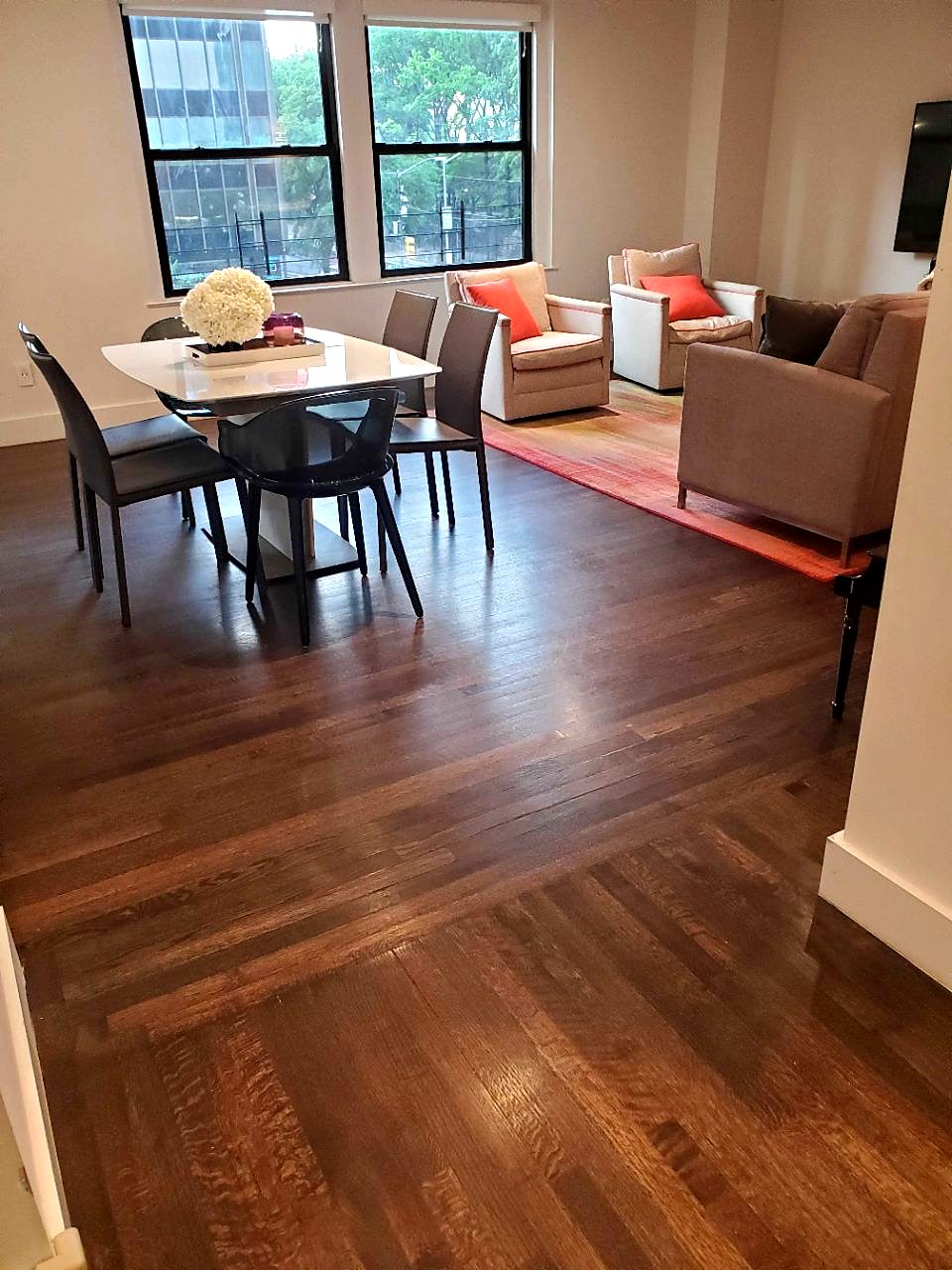 A freshly cleaned living and dining room with polished hardwood floors
