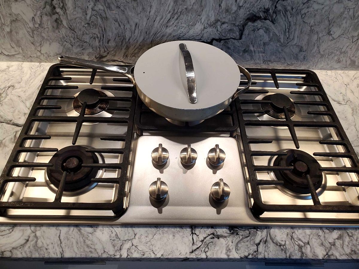The same stovetop after cleaning, spotless with grates back in place